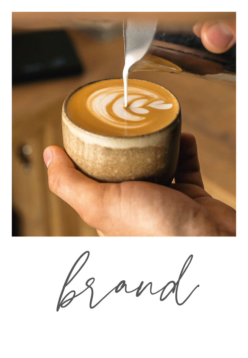 Detailní záběr na šálek cappuccina s latte art, nalévané mléko do kávy v ruce.